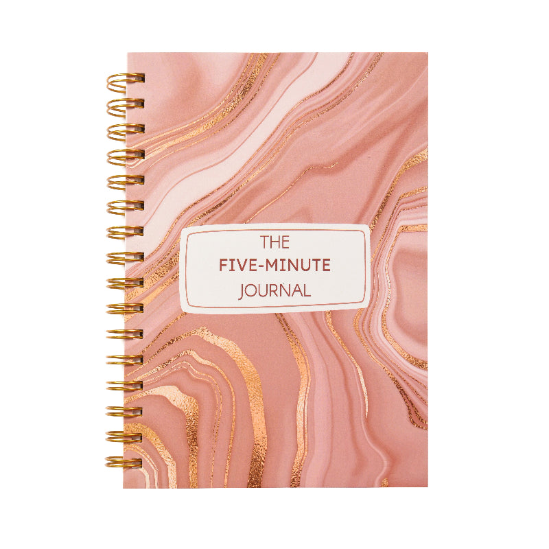 A rose quartz gratitude journal with a golden spiral hardcover, titled 'THE FIVE-MINUTE JOURNAL' on the front cover.