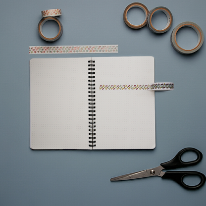 Open notebook with decorative tape and scissors on a gray background