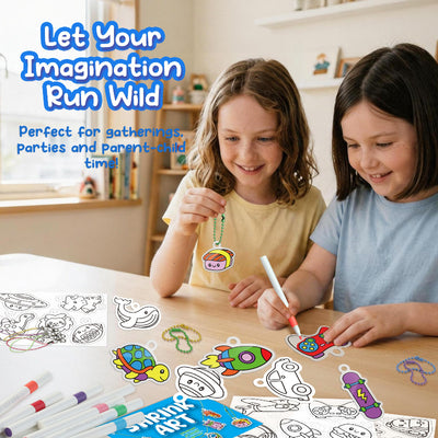 Two young girls smiling at a craft table colouring shrink art designs together, demonstrating a fun party or group activity.